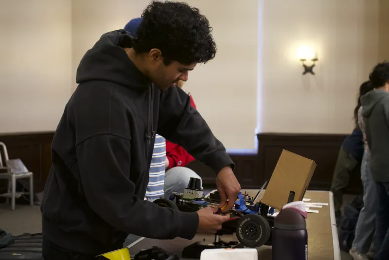 Nandagopal adjusting wiring on the F1/10 racecar